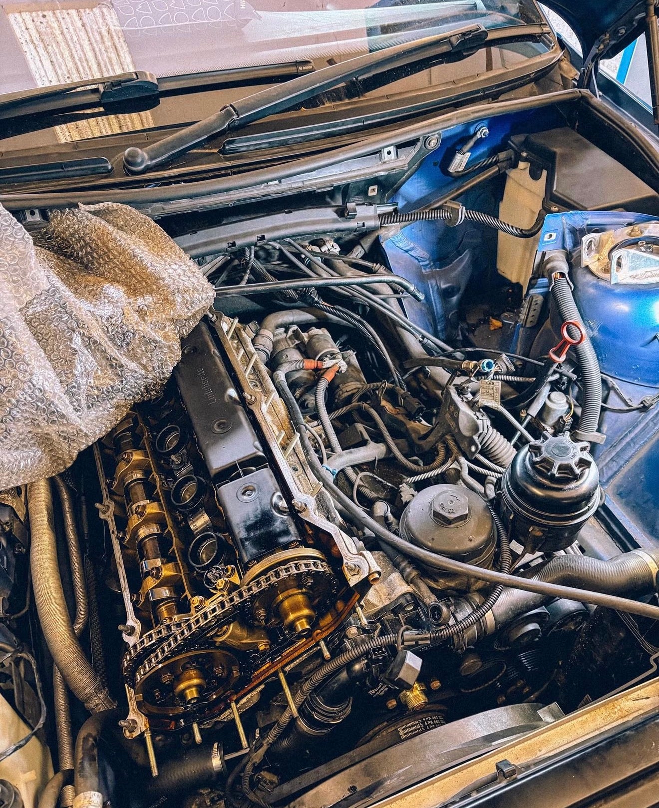 A BMW E46 Clubsport engine bay with the head and timing cover removed.