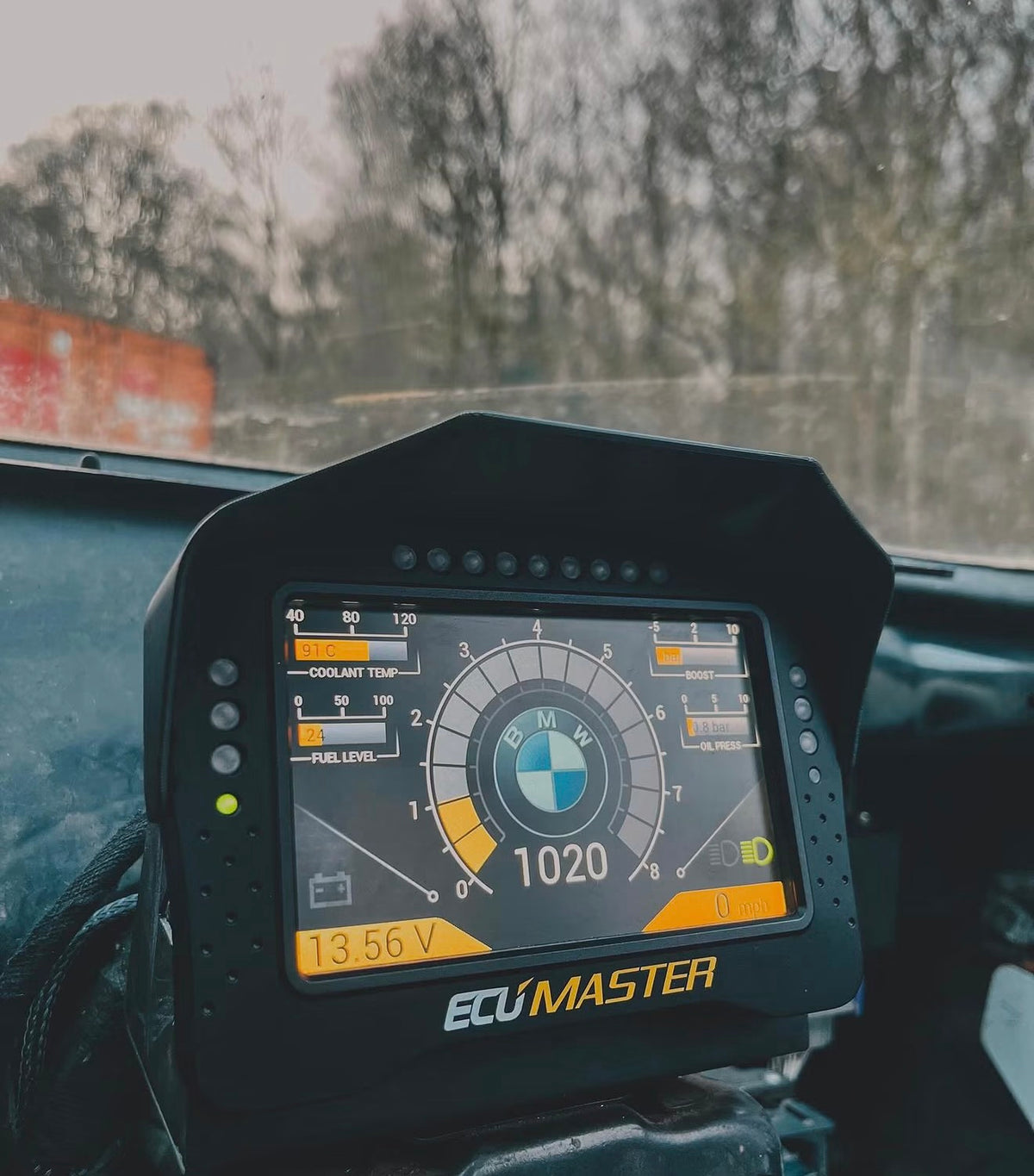 A BMW E30 M3 race car interior showing an ECUMaster dash.